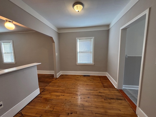 spare room featuring crown molding and dark hardwood / wood-style floors