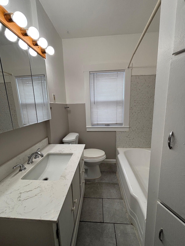 bathroom with tile patterned flooring, vanity, a bathtub, and toilet