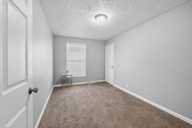 carpeted spare room with a textured ceiling