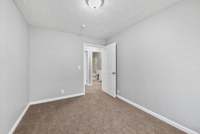 carpeted spare room featuring a textured ceiling