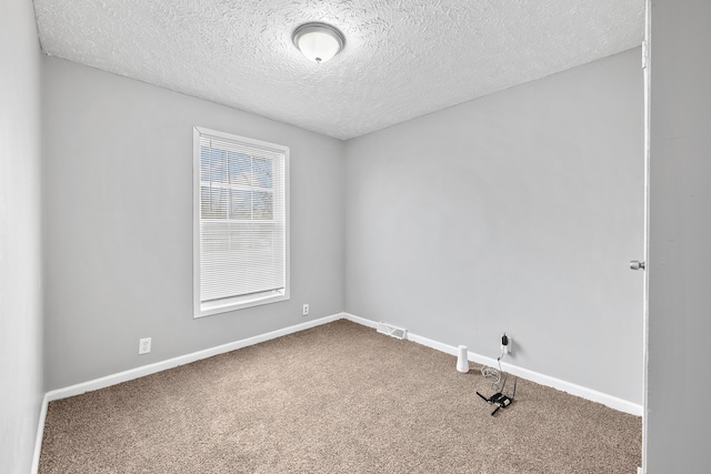 spare room with carpet flooring and a textured ceiling