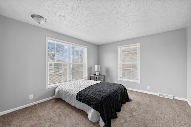 bedroom with carpet flooring and a textured ceiling