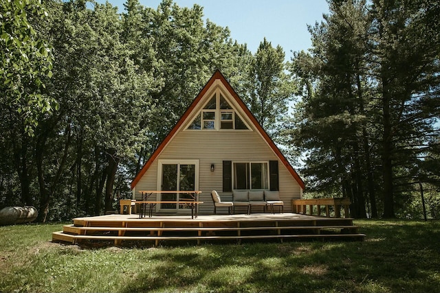 back of house with a wooden deck and a lawn