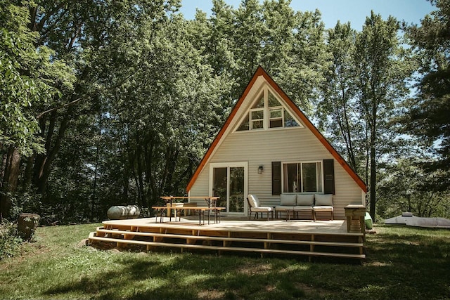 rear view of house with a wooden deck and a lawn