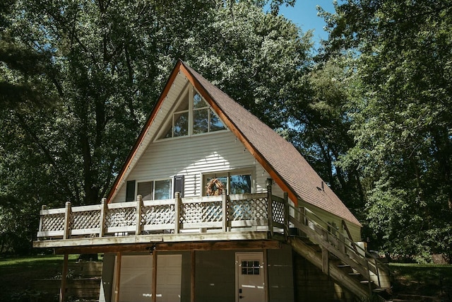 rear view of house with a garage and a deck