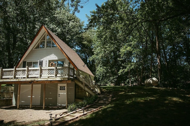 rear view of property with a garage and a wooden deck