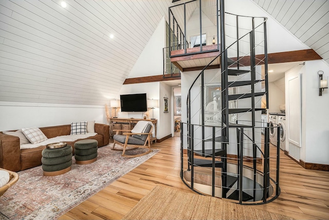 living room with high vaulted ceiling, washing machine and dryer, and light wood-type flooring