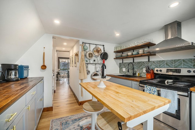 kitchen with stainless steel electric range oven, butcher block countertops, sink, gray cabinetry, and exhaust hood