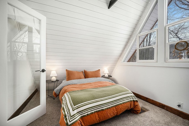 carpeted bedroom with vaulted ceiling with beams and wood walls