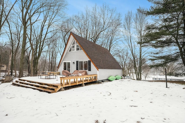 snow covered rear of property featuring a deck