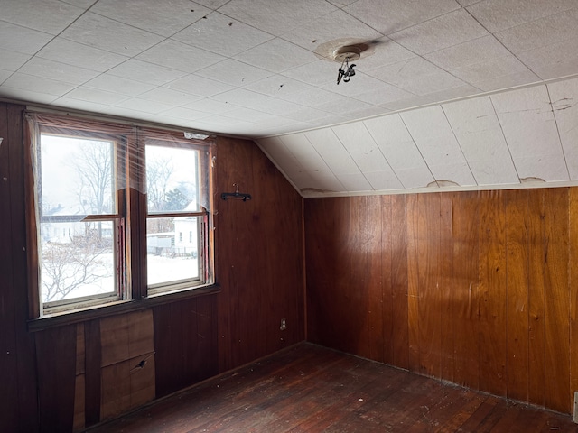 bonus room featuring lofted ceiling, dark hardwood / wood-style floors, and wood walls