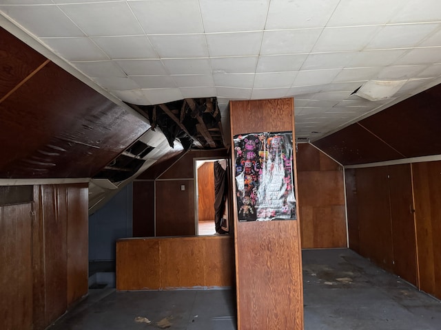 additional living space with vaulted ceiling and wooden walls