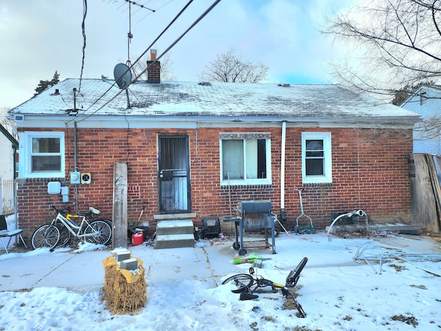 view of snow covered rear of property