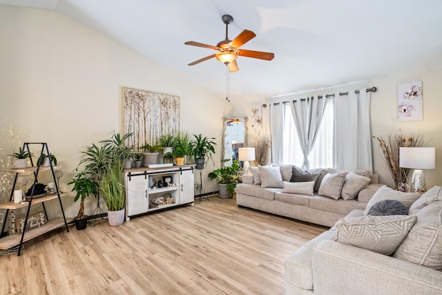 living room featuring ceiling fan, vaulted ceiling, and light wood-type flooring