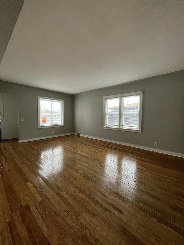 unfurnished room with dark wood-type flooring