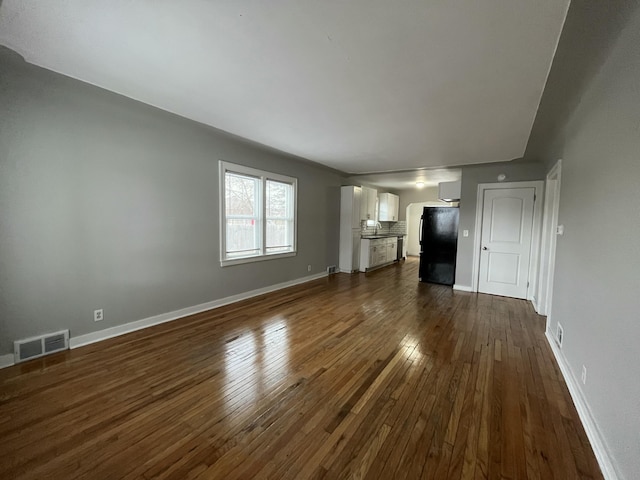 unfurnished living room with dark wood-type flooring and sink