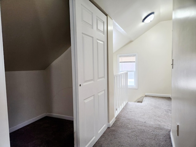 corridor featuring lofted ceiling and carpet flooring