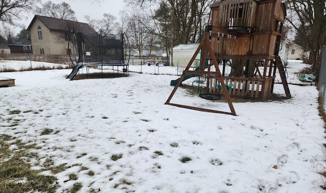 snow covered playground featuring a trampoline