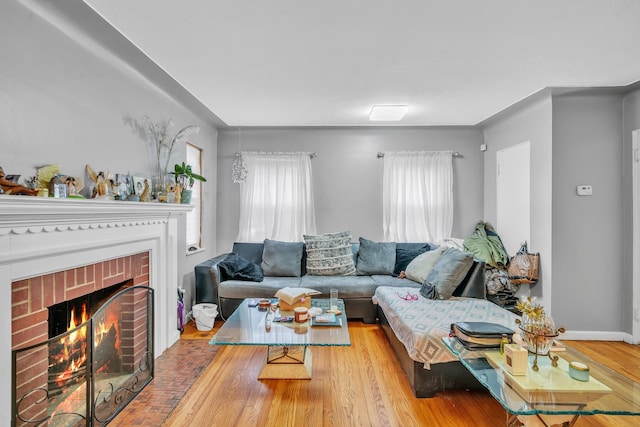 living room featuring a brick fireplace and light wood-type flooring