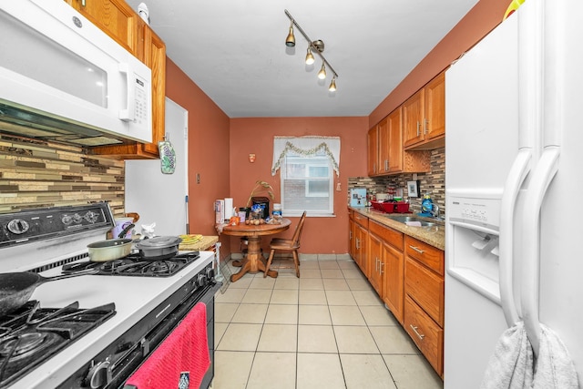 kitchen with light tile patterned flooring, sink, white appliances, and decorative backsplash