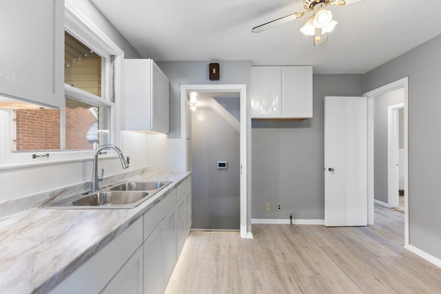 kitchen featuring tasteful backsplash, sink, white cabinets, and light hardwood / wood-style floors