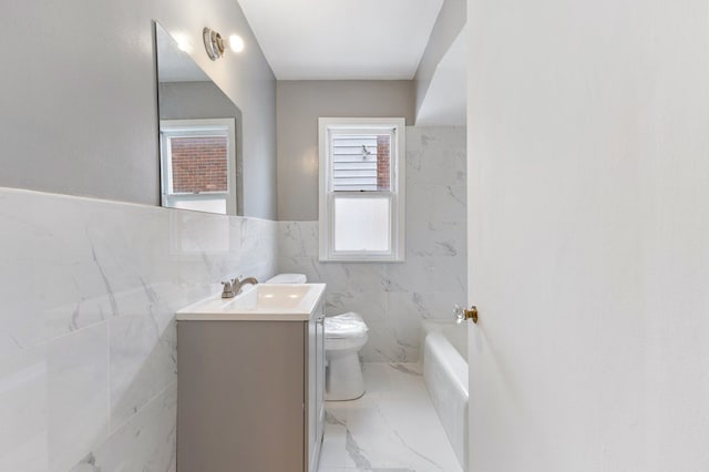 bathroom featuring vanity, toilet, and a tub