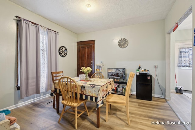 dining room featuring hardwood / wood-style floors and a textured ceiling