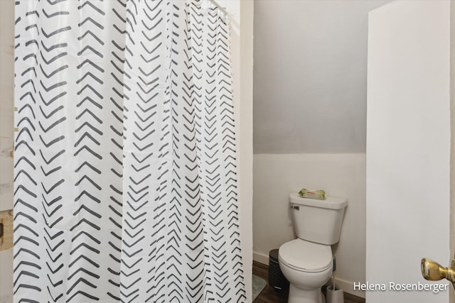 bathroom featuring curtained shower and toilet