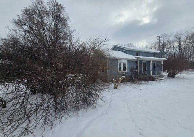 snow covered property featuring covered porch