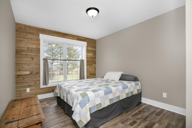 bedroom with dark hardwood / wood-style floors and wood walls