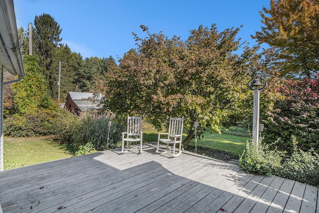 wooden terrace featuring a lawn