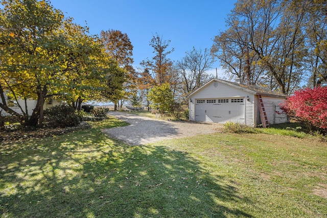 view of yard with a garage and an outbuilding