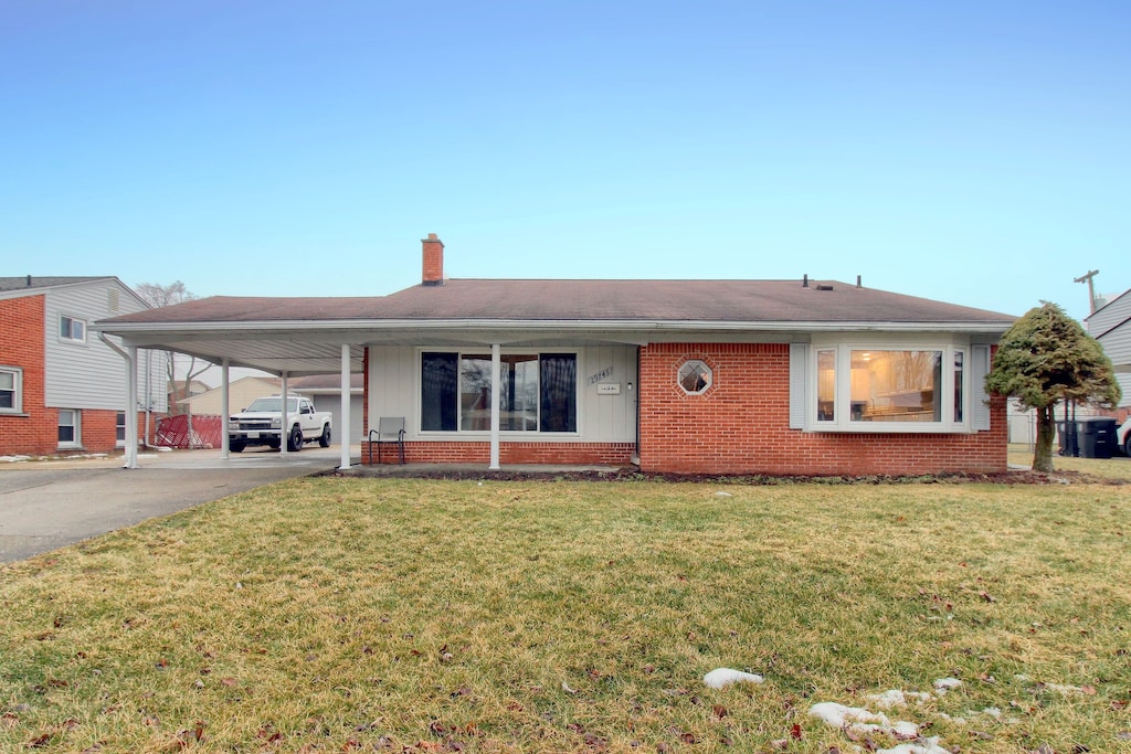 view of front of property featuring a carport and a front lawn