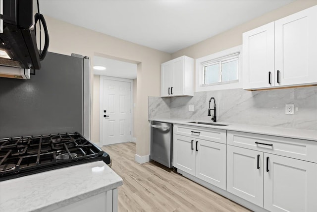 kitchen featuring stainless steel appliances, sink, white cabinets, and decorative backsplash