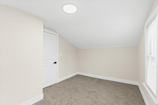 additional living space with light colored carpet and lofted ceiling