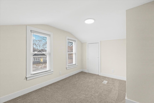 additional living space featuring lofted ceiling and carpet floors