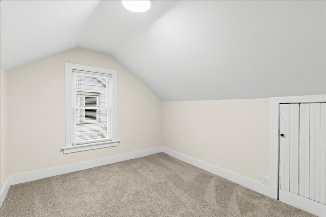 additional living space with vaulted ceiling and carpet floors