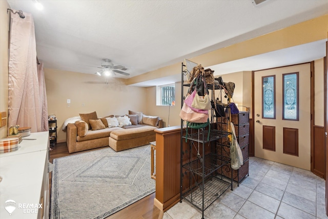 living room with light tile patterned floors and ceiling fan