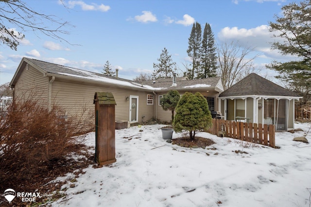 snow covered property featuring a sunroom