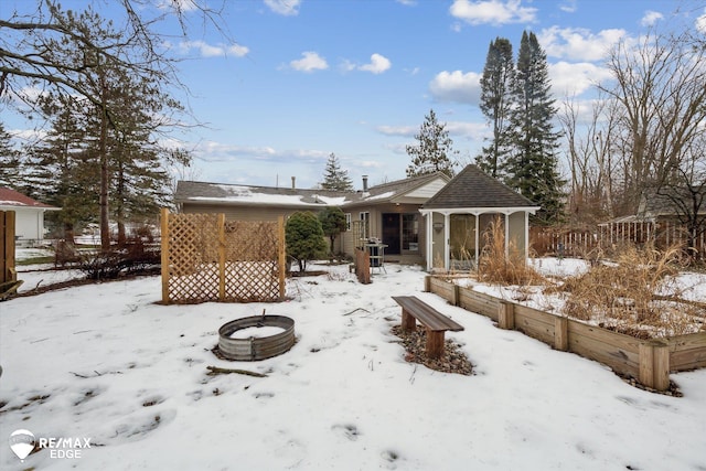 snow covered house featuring a fire pit