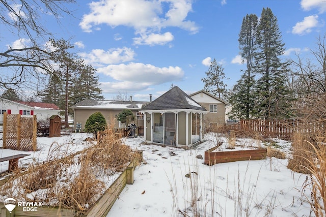 snow covered property with a sunroom