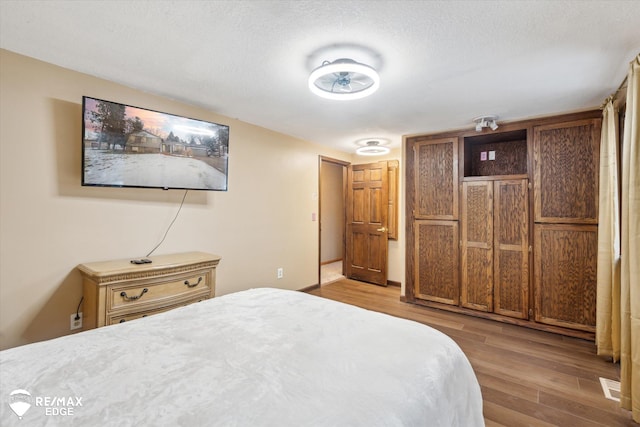 bedroom with hardwood / wood-style flooring and a textured ceiling