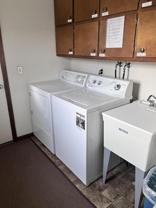 clothes washing area with cabinets, sink, and washing machine and clothes dryer