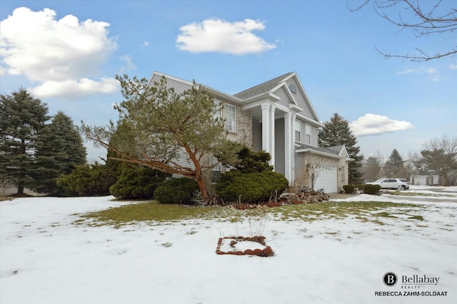 view of snowy exterior featuring a garage