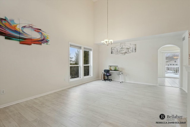 unfurnished dining area featuring a notable chandelier, plenty of natural light, and light wood-type flooring