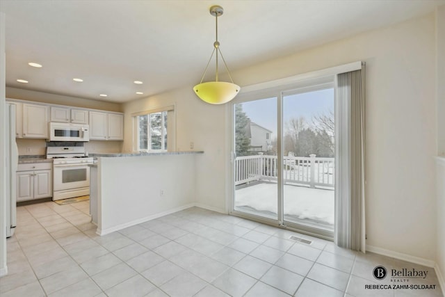 kitchen with white cabinetry, white appliances, a healthy amount of sunlight, and decorative light fixtures