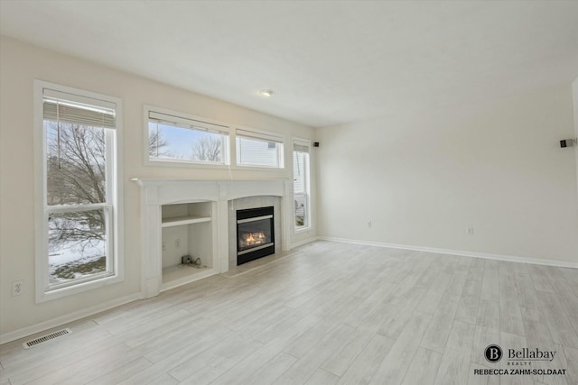 unfurnished living room with plenty of natural light and light hardwood / wood-style flooring