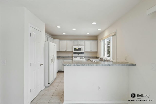 kitchen featuring white cabinetry, sink, white appliances, and kitchen peninsula