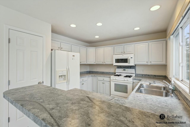 kitchen with sink, white cabinets, white appliances, and kitchen peninsula