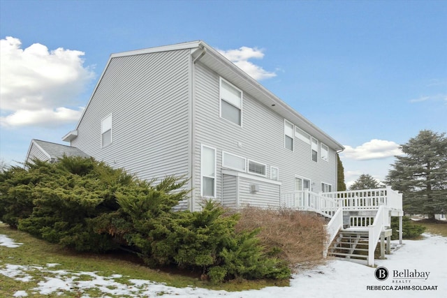 snow covered property with a deck